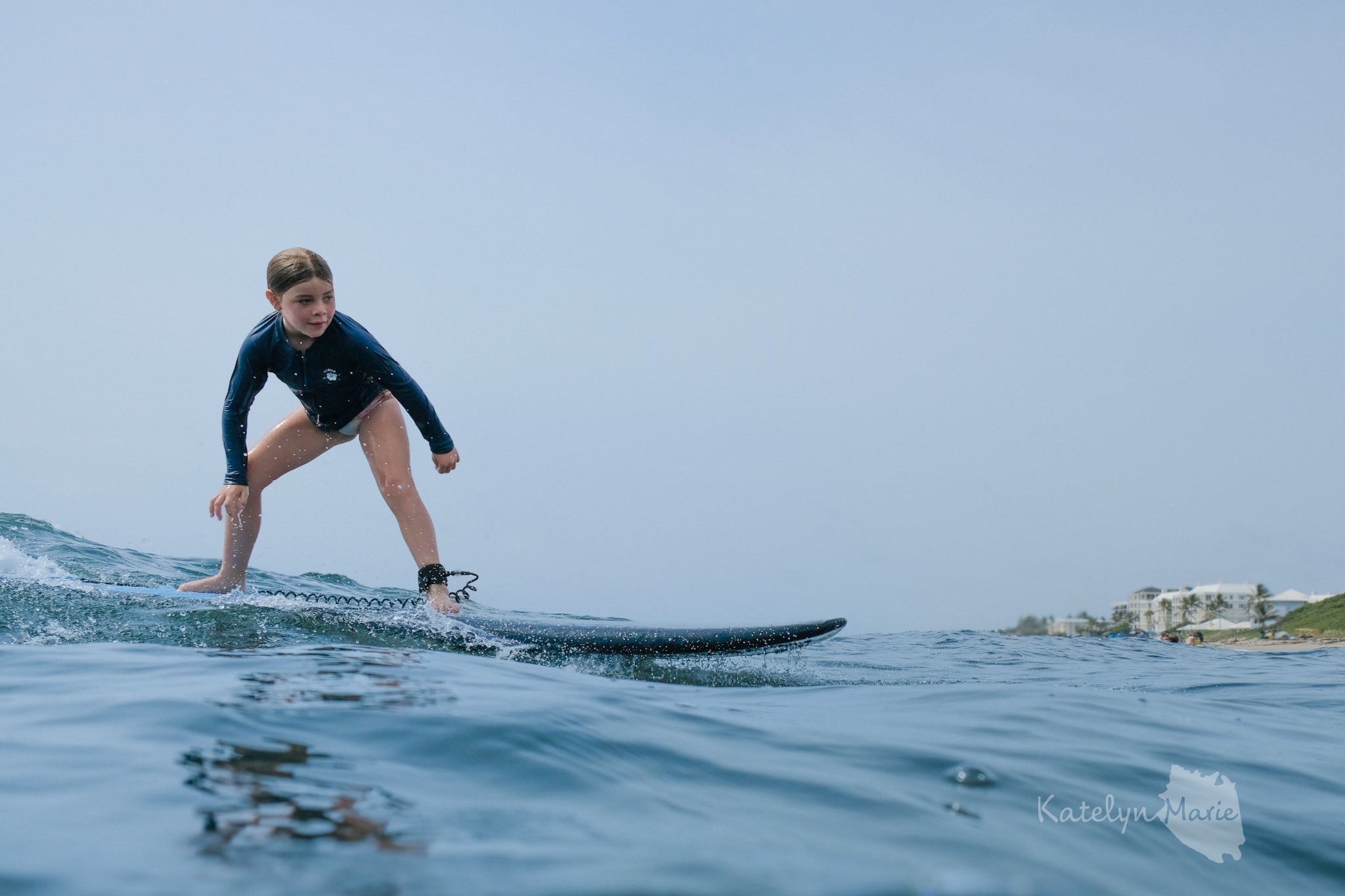 Person surfing on a wave with a clear sky background